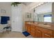 A bathroom features a double vanity, a window, and a door to a toilet and shower at 18605 Le Dauphine Pl, Lutz, FL 33558
