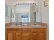 Bathroom featuring a double vanity with a large mirror and bright lighting at 18605 Le Dauphine Pl, Lutz, FL 33558