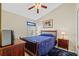 Comfortable bedroom featuring wood furniture, ceiling fan, and ample natural light at 18605 Le Dauphine Pl, Lutz, FL 33558