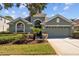 Charming single-story home featuring a two car garage and mature landscaping at 18605 Le Dauphine Pl, Lutz, FL 33558