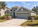A single-story home with a two car garage, complemented by a well-maintained lawn and driveway at 18605 Le Dauphine Pl, Lutz, FL 33558