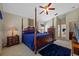 A large, carpeted main bedroom features a four poster bed and ceiling fan at 18605 Le Dauphine Pl, Lutz, FL 33558
