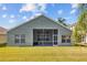 Home rear exterior with lawn, patio, and view to a neighboring pool at 18605 Le Dauphine Pl, Lutz, FL 33558
