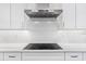 Modern kitchen with sleek stainless range hood over induction cooktop and beautiful white countertops at 242 Estado Ne Way, St Petersburg, FL 33704