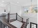 Bright staircase features a decorative chandelier, iron railing and wood steps for a grand entrance to the second floor at 242 Estado Ne Way, St Petersburg, FL 33704