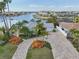 Beautiful waterfront home showcasing lush landscaping, a brick driveway, and canal views at 6446 Lake Sunrise Dr, Apollo Beach, FL 33572