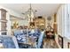 Stylish dining area with wooden table set for meal, artistic chandelier, and view into kitchen at 6446 Lake Sunrise Dr, Apollo Beach, FL 33572