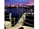 Night view of a private dock, featuring atmospheric lighting, set against a backdrop of a picturesque waterway at dusk at 6446 Lake Sunrise Dr, Apollo Beach, FL 33572