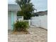 Paver driveway with a white fence surrounding the property and tropical landscaping enhances the curb appeal at 6446 Lake Sunrise Dr, Apollo Beach, FL 33572