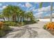 A beautiful exterior view of a waterfront property featuring lush landscaping and a well-maintained brick driveway at 6446 Lake Sunrise Dr, Apollo Beach, FL 33572