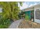 Charming front entrance with stone pathway and lush tropical foliage creating an inviting and serene welcome at 6446 Lake Sunrise Dr, Apollo Beach, FL 33572