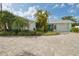 Charming front exterior of a home featuring lush tropical landscaping, well-maintained lawn, and a brick paved driveway at 6446 Lake Sunrise Dr, Apollo Beach, FL 33572