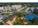 A high-angle shot reveals tennis courts and condominiums nestled amidst lush greenery at 1200 N Shore Ne Dr # 204, St Petersburg, FL 33701