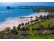 Scenic aerial view of a beach with a pier, palm trees, and green space nearby at 1200 N Shore Ne Dr # 204, St Petersburg, FL 33701