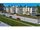 Multi-story condominium building featuring private balconies and a well-maintained lawn with palm trees and nearby city road at 1200 N Shore Ne Dr # 204, St Petersburg, FL 33701