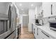 Stylish kitchen with stainless steel appliances, modern white cabinets, and stone countertops at 1200 N Shore Ne Dr # 204, St Petersburg, FL 33701