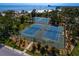 Overhead view of well-maintained blue tennis courts surrounded by mature landscaping and lighting at 1200 N Shore Ne Dr # 204, St Petersburg, FL 33701