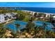 Overhead shot of community tennis courts surrounded by lush greenery and a parking lot near a beach at 1200 N Shore Ne Dr # 204, St Petersburg, FL 33701