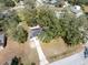 Aerial view of a quaint home nestled among mature trees and a long driveway, offering privacy and curb appeal at 402 W Jersey Ave, Brandon, FL 33510