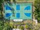 Aerial view of a basketball court with blue and green accents, fully fenced in at 4446 Wildstar Cir, Wesley Chapel, FL 33544