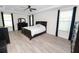 Bright bedroom with a ceiling fan, a bed, two dressers, and two windows with dark blue curtains at 4446 Wildstar Cir, Wesley Chapel, FL 33544