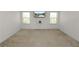 Carpeted bedroom with natural light and a mounted TV, creating a cozy and functional space at 4446 Wildstar Cir, Wesley Chapel, FL 33544
