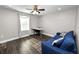 Inviting bedroom with a stylish blue sofa, modern desk, and ample natural light from the large window at 4446 Wildstar Cir, Wesley Chapel, FL 33544