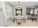 Dining area with a modern chandelier, table for four, and sliding glass door at 4446 Wildstar Cir, Wesley Chapel, FL 33544