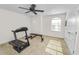 Exercise room features carpet floors, a ceiling fan, a large window and exercise equipment at 4446 Wildstar Cir, Wesley Chapel, FL 33544
