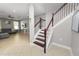 Elegant foyer showcasing a staircase with wood and white railings, complemented by neutral tones and tiled flooring at 4446 Wildstar Cir, Wesley Chapel, FL 33544