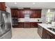 Modern kitchen with dark wood cabinets, stainless steel appliances, and white countertops at 4446 Wildstar Cir, Wesley Chapel, FL 33544