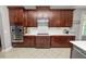 Stylish kitchen featuring dark wood cabinets, stainless steel appliances, and bright backsplash at 4446 Wildstar Cir, Wesley Chapel, FL 33544