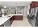 Kitchen with island, stainless steel appliances and tile flooring that leads to the staircase at 4446 Wildstar Cir, Wesley Chapel, FL 33544