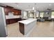 Open kitchen featuring an island with white countertop, dark wood cabinets, and stainless steel appliances at 4446 Wildstar Cir, Wesley Chapel, FL 33544