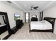 This main bedroom has wood-look floors, a ceiling fan, and a TV for comfortable living at 4446 Wildstar Cir, Wesley Chapel, FL 33544