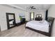 Cozy main bedroom features wood-look floors, a ceiling fan, and neutral tones for relaxation at 4446 Wildstar Cir, Wesley Chapel, FL 33544