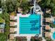 Overhead aerial view of a large rectangular pool and lounge area with umbrellas and a water slide at 4446 Wildstar Cir, Wesley Chapel, FL 33544