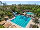 Aerial view of the community pool with lap lanes and a water slide surrounded by trees and lounge chairs at 4446 Wildstar Cir, Wesley Chapel, FL 33544