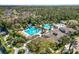 Beautiful aerial view of the community pool area with a slide and splash pad surrounded by lush landscaping at 4446 Wildstar Cir, Wesley Chapel, FL 33544