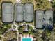 Aerial view of four well-maintained tennis courts near a swimming pool and clubhouse at 4446 Wildstar Cir, Wesley Chapel, FL 33544