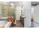 Bright bathroom featuring a luxurious tub, glass shower, and vanity with double sinks at 5010 W Dickens Ave, Tampa, FL 33629