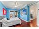 Bright bedroom featuring a queen-sized bed, hardwood floors and windows overlooking the neighborhood at 5010 W Dickens Ave, Tampa, FL 33629