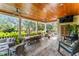 Covered outdoor patio with wood ceilings, ample seating, and dining area at 5010 W Dickens Ave, Tampa, FL 33629