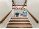 View from the stairs to the hardwood floors, wood beams, and open-concept living room at 5010 W Dickens Ave, Tampa, FL 33629