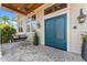 Inviting front porch with blue double doors, gray stone floors, and a porch swing at 5010 W Dickens Ave, Tampa, FL 33629