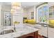 Bright, updated kitchen with center island, white cabinets, and large window for natural light at 5010 W Dickens Ave, Tampa, FL 33629