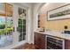 Charming wet bar area with wine fridge, granite countertop, storage, and french doors to the outside at 5010 W Dickens Ave, Tampa, FL 33629