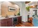 Elegant wet bar area near fireplace with granite countertop, wine fridge, and modern finishes at 5010 W Dickens Ave, Tampa, FL 33629