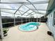 Enclosed pool with blue water surrounded by a light-colored patio and white screen at 8341 Moulton Dr, Port Richey, FL 34668
