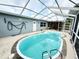 Backyard pool enclosed with white screening, light colored patio, and light grey house at 8341 Moulton Dr, Port Richey, FL 34668